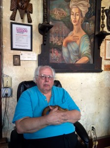 Dr. John T. sits under the portrait of Marie Laveau